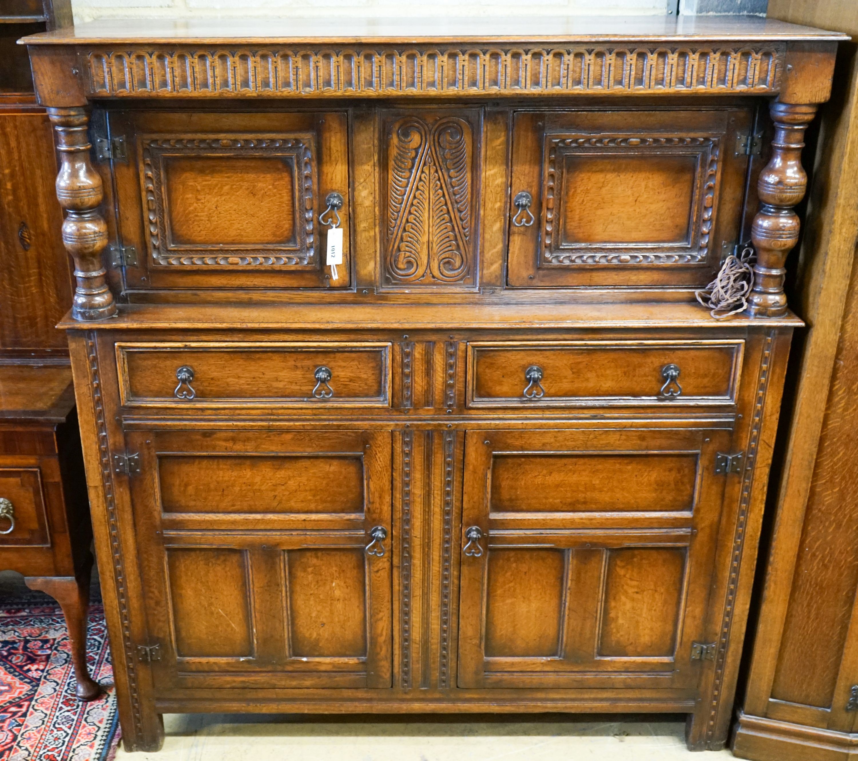A 17th century style carved and panelled oak court cupboard